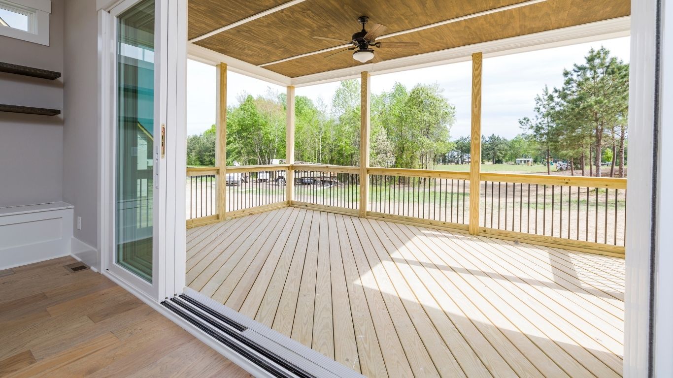 Covered and screened-in deck with ceiling fan overlooking a backyard in Indiana